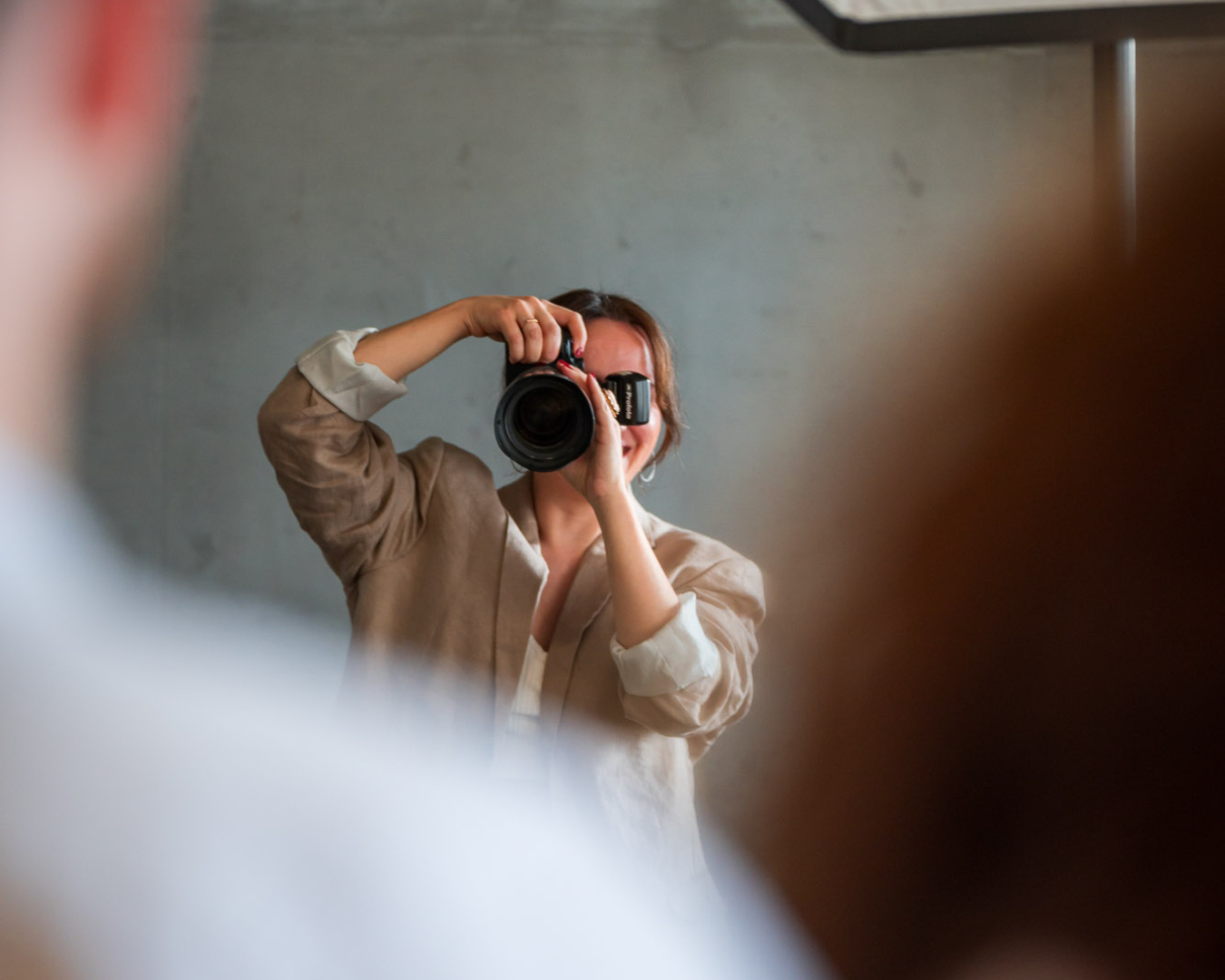 ava_2024161 eine frau, fotografin, mit kamera vor gesicht